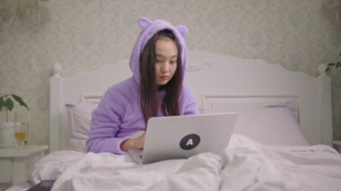 20 'li yaşlarda Asyalı bir kadın laptopta iyi haberler okuyor. Genç yetişkin bir kadın dizüstü bilgisayarını öperken çok mutlu. Neşeli kadın şaşırtıcı duygular gösterir..