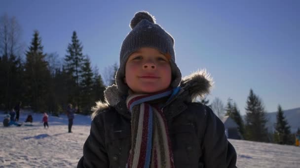 Portret van een kind dat op de winterberg staat. — Stockvideo