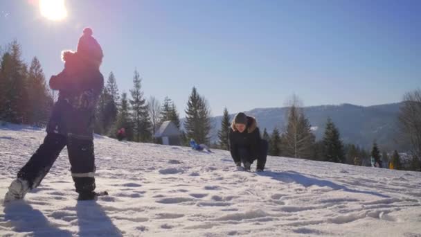 Мать и сын играют со снегом на зимней горе. Счастливая семья играет вместе на улице. Зимние семейные мероприятия. — стоковое видео
