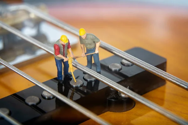 在Bass Guitar皮卡上工作的微型工人 — 图库照片