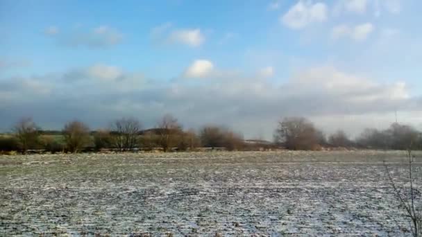 Медленный проход через ландшафт с полем и немного снега — стоковое видео