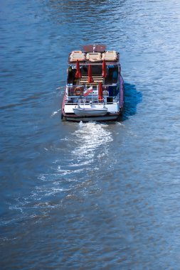 Small boat with a dinghy on the back on a river clipart