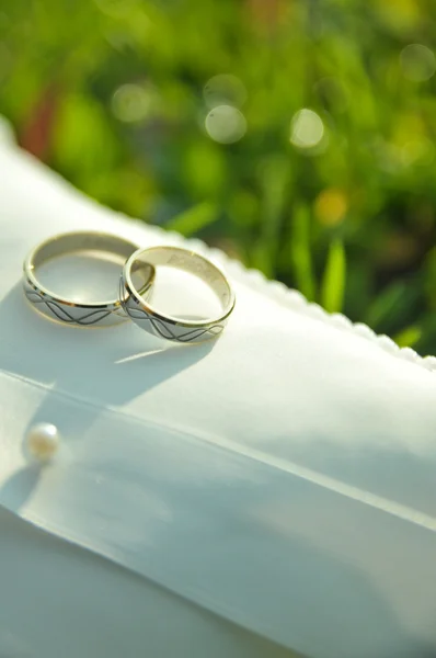 Anillos de boda en almohada blanca — Foto de Stock