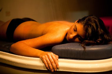 Lying relaxed woman during spa treatment. clipart