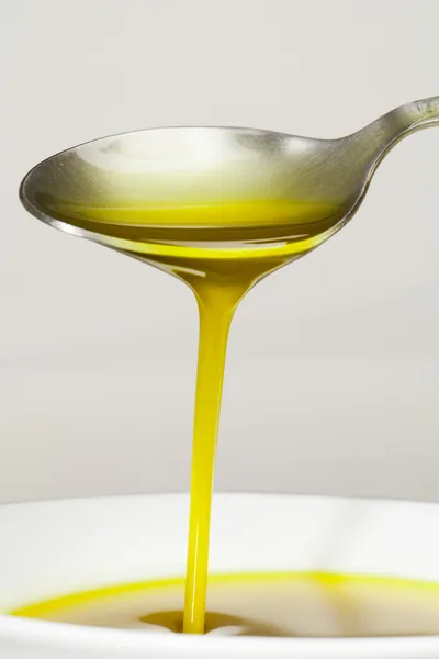 Aceite de oliva cayendo sobre una cuchara — Foto de Stock