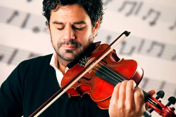 Violinist playing with a stave background — Stock Photo, Image