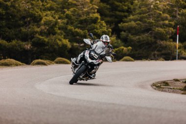 Sierra de los Filabres, Spain - May 5th 2021: Motorbike rider riding a BMW R 1250 GS motorcycle in a mountain road across beautiful turns, during Dunlop Xperience event in Sierra de los Filabres, Spain.