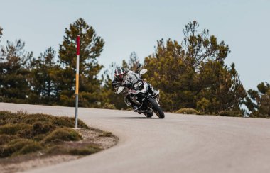 Sierra de los Filabres, Spain - May 5th 2021: Motorbike rider riding a BMW R 1250 GS motorcycle in a mountain road across beautiful turns, during Dunlop Xperience event in Sierra de los Filabres, Spain.