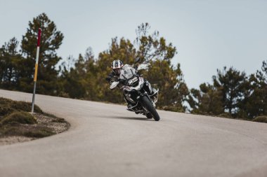 Sierra de los Filabres, Spain - May 5th 2021: Motorbike rider riding a BMW R 1250 GS motorcycle in a mountain road across beautiful turns, during Dunlop Xperience event in Sierra de los Filabres, Spain.