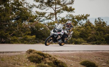 Sierra de los Filabres, Spain - May 5th 2021: Motorbike rider riding a BMW R 1250 GS motorcycle in a mountain road across beautiful turns, during Dunlop Xperience event in Sierra de los Filabres, Spain.