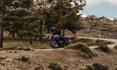 Calar Alto, İspanya - 5 Mayıs 2021: Almerya, İspanya 'da Dunlop Xperience etkinliği sırasında çam ağaçları arasında Yamaha XSR700 motosikleti süren adam.