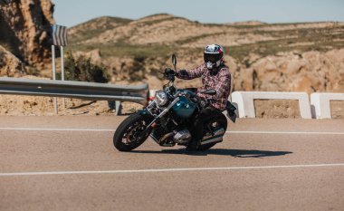 Almerya, İspanya - 5 Mayıs 2021: Almerya dağ sırasındaki Dunlop Xperience etkinliği sırasında, bir dağ yolunda BMW R NineT motorsikletine binen adam, İspanya.