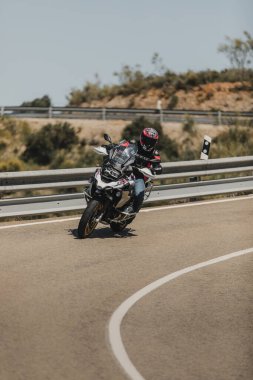 Almerya, İspanya - 5 Mayıs 2021: Almerya, İspanya 'da Dunlop Xperience etkinliği sırasında bir dağ yolunda BMW R 1250 GS motosikleti süren adam.