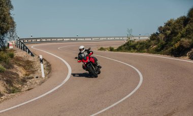 Almeria, İspanya - 5 Mayıs 2021: Almeria, İspanya 'da Dunlop Xperience etkinliği sırasında Yamaha Tracer 7 motosikletli bir adam güzel virajlar arasında bir dağ yolunda.