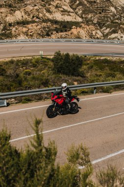 Almeria, İspanya - 5 Mayıs 2021: Almeria, İspanya 'da Dunlop Xperience etkinliği sırasında Yamaha Tracer 7 motosikletli bir adam güzel virajlar arasında bir dağ yolunda.