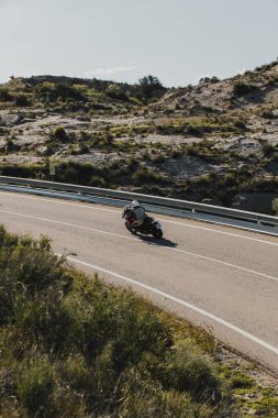 Almeria, İspanya - 5 Mayıs 2021: Almeria, İspanya 'da Dunlop Xperience etkinliği sırasında Yamaha Tracer 7 motosikletli bir adam güzel virajlar arasında bir dağ yolunda.