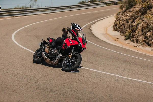 Almeria, İspanya - 5 Mayıs 2021: Almeria, İspanya 'da Dunlop Xperience etkinliği sırasında Yamaha Tracer 7 motosikletli bir adam güzel virajlar arasında bir dağ yolunda.