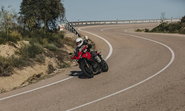 Almeria, İspanya - 5 Mayıs 2021: Almeria, İspanya 'da Dunlop Xperience etkinliği sırasında Yamaha Tracer 7 motosikletli bir adam güzel virajlar arasında bir dağ yolunda.