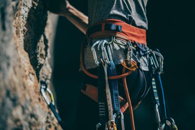 Tırmanış takımları ve ekipmanların ayrıntıları. Tırmanış takımlarına bağlı bir kadın bir rotaya tırmanıyor.