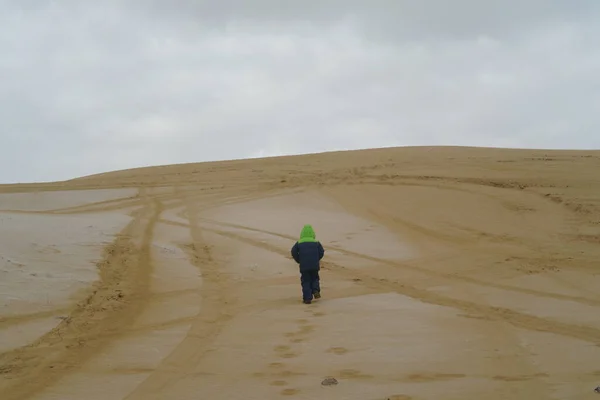 A child walking on the sands of the dunes in the desert alone — Stock Photo, Image