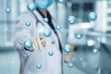 Doktor bulanık arkaplandaki sıcaklık ölçüm simgesine tıklıyor.