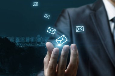 E-posta iletimi ve dağıtım konsepti. El, bulanık arkaplanda e- postaları gösterir.