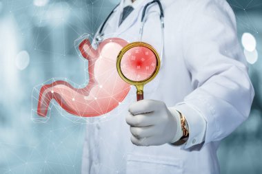 Doktor bakteri ve virüsler için hastanın midesini muayene eder..
