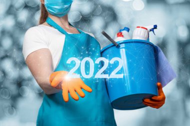 Temizlikçi kadın 2022 yılını bulanık bir arkaplanda gösteriyor..