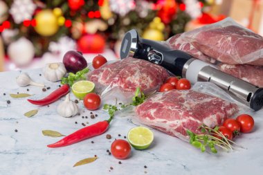 Süpürge paketlenmiş et ve sebzeler ve arka planda Noel ağacı olan sous vide pişirme cihazı..