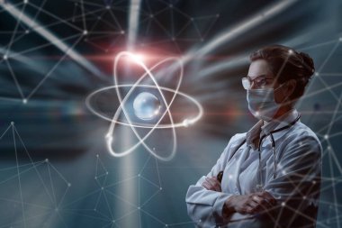 A woman in a mask in uniform looks at an atom on a blurred background. The concept of innovative technologies in the study of atoms.