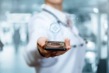 Doktor telefonda sağlık kurumunun yerini gösteriyor..