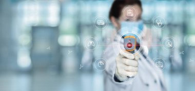 Doktor sanal bir bilgisayarın arayüzünde sıcaklığı ölçen bir cihaz gösteriyor..