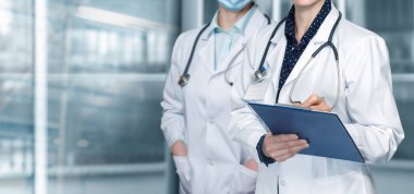 Bir grup doktor bulanık bir arka planda duruyor..