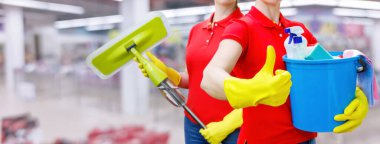 Toplu temizlik kavramı. Bir grup temizlikçi kadın bulanık bir arka planda duruyor..