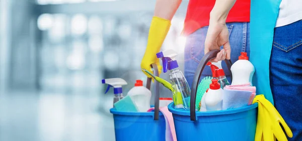 Kovalı temizleyiciler ve temizlik ürünleri bulanık bir arka planda duruyor.