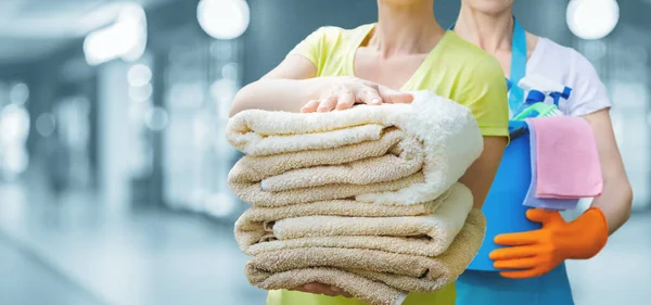 Haushälterinnen Mit Putzutensilien Und Bettwäsche Stehen Vor Verschwommenem Hintergrund — Stockfoto