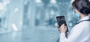 Doctor working on tablet with virtual interface on blurred background.