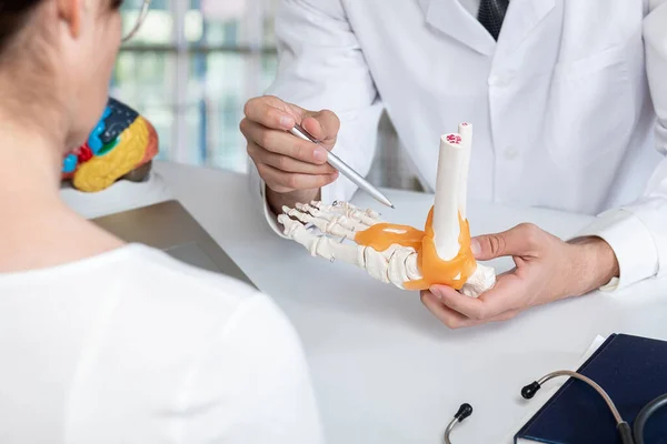 Medic Shows Ankle Diseases Patient Table —  Fotos de Stock