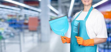 Cleaner with dustpan and brush on blurred background.