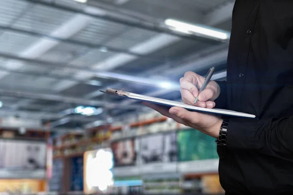 Man Counts Goods Warehouse Man Writes Checklist Pen Blurred Background — Photo