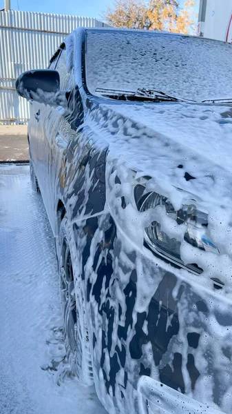 Foam after auto shampoo on the car at the car wash