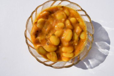 Beyaz arka planda şeffaf kasede servis edilen lezzetli Vaal nu shaak veya tereyağlı fasulye körisi. Lezzetli Hint usulü körili fasulye ya da bakla