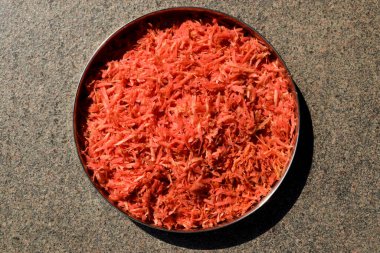 Gajar ka halwa gibi havuç tarifleri yapmak için taze rendelenmiş havuç sebze hazırlığı. Tabakta rendelenmiş havuç