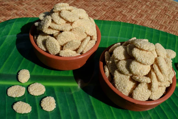 Rewri or Sesame seed sugar jaggery, Indian Sankranti festical food item. Rewri gajak served in earthen pot bowl on banana leaf