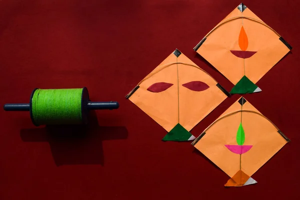 Makar Sankranti background for festive greetings and wishes.Kites and spool on red background. Makar sankranti Indian festival posters for Uttarayan, Lohri and Pongal. Kite festival. Patang aur Manjha
