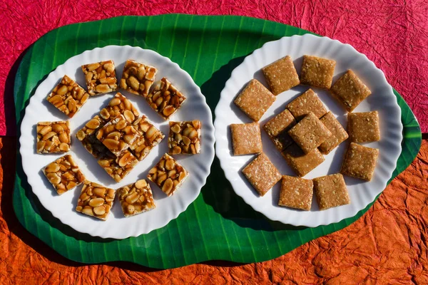 Tasty traditional Indian sweet Jaggery Peanut chikki and Crushed peanut chikki bars on colorful background. Crunchy peanut brittles bar for Sankranti festival. Makarsankranti, uttarayan, lohri food