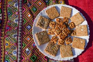 Sankrant özel yemeği Peanut Chikki ve Til chikki, jaggery ve susamlı, yer fıstığı servisi. Makarsankranti ve Uttarayan boş uzayı kutluyorlar.