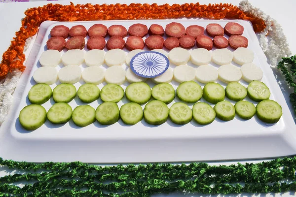 Republic day of india Food tricolour concept. Inda flag three colors depicted by carrot, radish, cucumber sliced with ashok chakra with ribbon decoration. Indian independence day food theme ideas.