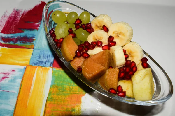 Mix fruit salad chaat of sliced bananas, grapes, cut cheeku, pear and apples with green grapes. Mix fruit dish.