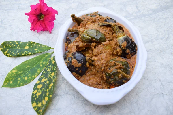 Hint usulü brinjal veya patlıcan soslu baharatlı köri. Beyaz arka planda dekore edilmiş kase.